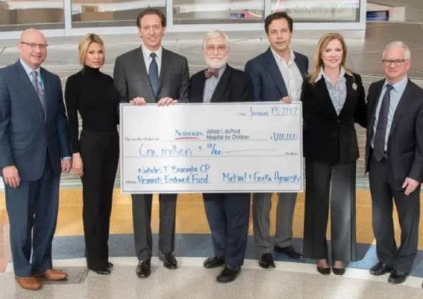 Pleople are showing cheque in this photo.